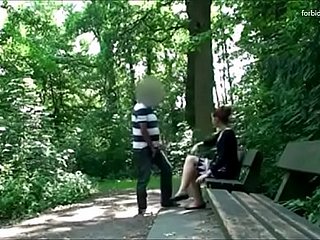 Man thân một người phụ nữ trong một công viên